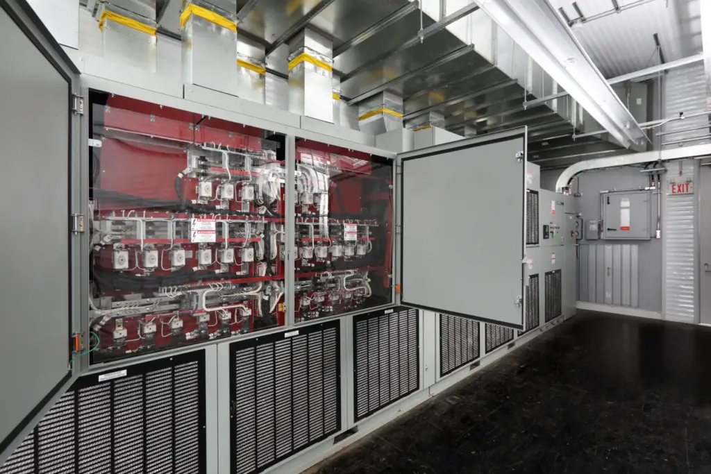 Medium-voltage drive with its power section visible behind a clear barrier inside an electrical building